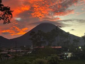 a mountain with a sunset in the background at Villa Arenal Volcano & Privade pool in Fortuna
