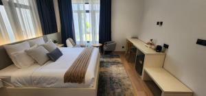 a bedroom with a large bed with a desk and window at Anona Beachfront Villa in Filadu