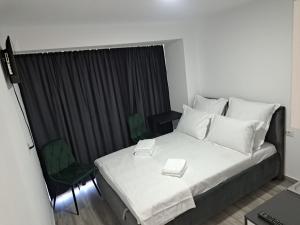 a hotel room with a bed and a chair at Olimp Sea View Studio in Olimp