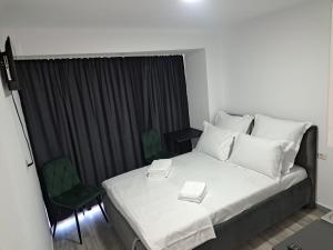 a bedroom with a bed and a green chair at Olimp Sea View Studio in Olimp +2 photos