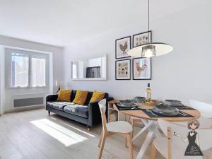 a living room with a table and a couch at La petite Maison Rouge in Igon
