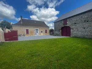 a large brick building with a large grass yard at La petite Maison Rouge in Igon