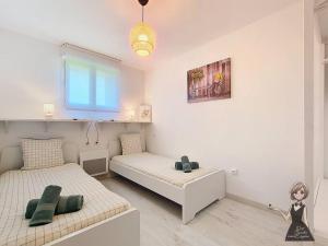 a bedroom with two beds and a doll on the floor at La petite Maison Rouge in Igon