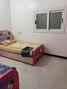 a small bedroom with a bed and a window at Sunny said gust house in Al Aqālitah