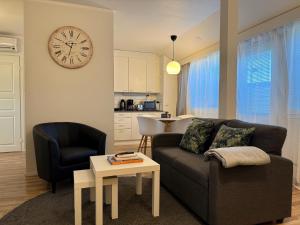 a living room with a couch and a table and a clock at Hamina Bastion Apartments in Hamina