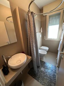 a small bathroom with a toilet and a sink at Rifugio a due passi dal mare in Rimini +6 photos