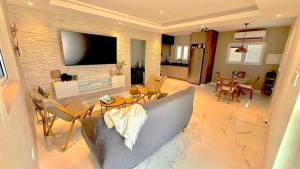 a living room with a couch and a dining room at Petit Paradise in Noord