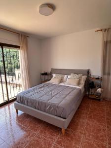 a bed in a bedroom with a large window at Casa Agner in Adsubia
