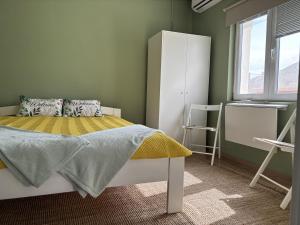 a bedroom with a bed and a refrigerator and a window at Home for two in Igal