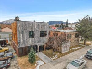 a large wooden house with cars parked in a parking lot at Hauser House Unit 1 Dog Friendly in Red Lodge