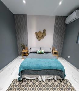 a bedroom with a large bed with a blue blanket at Petit Paradise in Noord