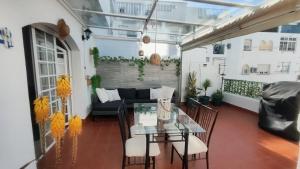 a balcony with a table and chairs and a couch at PISO AURORA in Barbate
