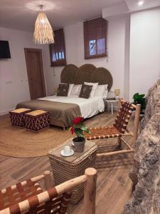 a bedroom with a large bed and a table and chairs at Raíces de Canillas Holiday Apartments in Canillas de Aceituno