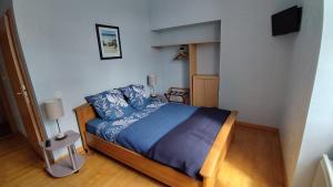 a bedroom with a bed with a blue comforter at Le Balcon de la Pierre Claire in Villersexel