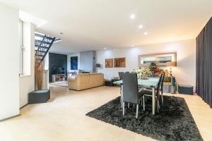 a dining room and living room with a table and chairs at Host In Olivença in Vila Nova de Famalicão