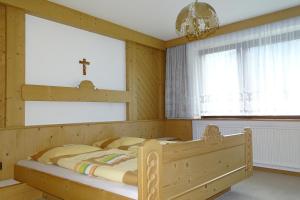 1 Schlafzimmer mit einem Holzbett und 2 Fenstern in der Unterkunft Haus Bergfried in Trins