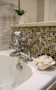 um lavatório de casa de banho com uma torneira e uma cesta de toalhas em Sankence lodge em Aylsham