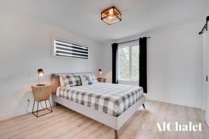 a white bedroom with a bed and a window at White Stag - Comfort & Serenity - Sauna & Pool in Pont-Rouge
