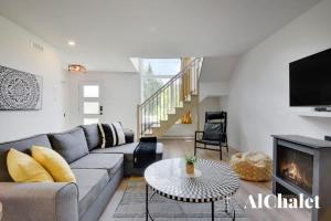 a living room with a couch and a fireplace at White Stag - Comfort & Serenity - Sauna & Pool in Pont-Rouge