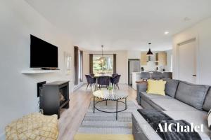a living room with a couch and a fireplace at White Stag - Comfort & Serenity - Sauna & Pool in Pont-Rouge