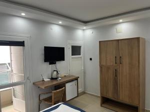 a room with a desk and a cabinet and a television at Caretta Vita Bella in Silifke