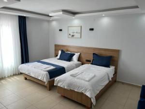 a bedroom with two beds with blue pillows at Caretta Vita Bella in Silifke