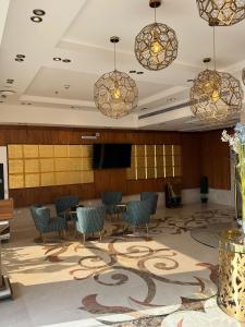 a lobby with chairs and tables and chandeliers at Lanai Hotel فندق لاناي in Jeddah