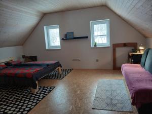 a attic room with a bed and two windows at Chalupa Nad Hladinou in Teplice nad Metují