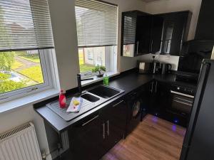 a small kitchen with a sink and a window at Bellshill 2 Bed Apartment in Bellshill