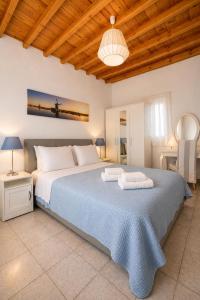 a bedroom with a large bed with a blue blanket at Villa Oceania in Tourlos