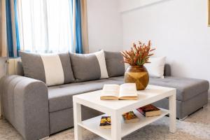 a living room with a couch and a table with books at Villa Oceania in Tourlos +47 photos
