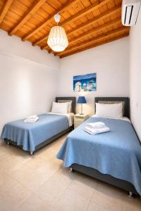 two beds sitting next to each other in a bedroom at Villa Oceania in Tourlos
