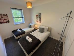 a room with two beds and a lamp in it at Bellshill 2 Bed Apartment in Bellshill