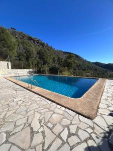 a swimming pool on a stone floor with a mountain at Casa Agner in Adsubia