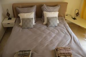 a large bed with four pillows on it at Casa Albinelor - Apartament 2-6 persoane in Braşov