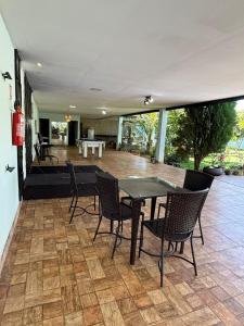 a patio with a table and chairs and a couch at Refúgio Garden Eventos in Senador Canedo