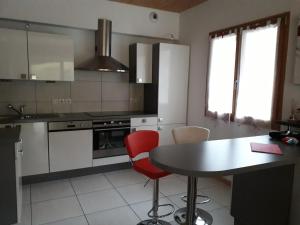 a kitchen with a table and red chairs in it at CHALET AU CALME à GERARDMER in Gérardmer