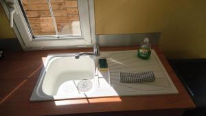 a sink in a kitchen with a window at Bungalow entre oliviers et pins, -10mn de la plage in Châteauneuf-lès-Martigues