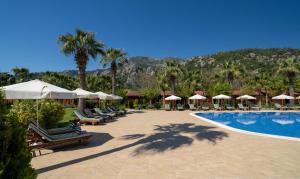 a resort with a swimming pool with chairs and umbrellas at Odile Hotel by Naturelife in Cıralı