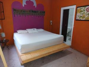 a bed in a room with orange walls at Sayu Life in Sayulita