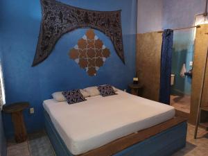a bedroom with a bed in a blue room at Sayu Life in Sayulita