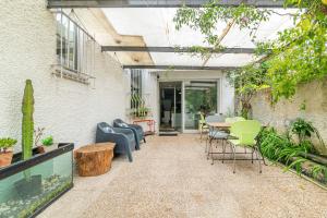 an outdoor patio with chairs and a table and a table and chairs at Host In Olivença in Vila Nova de Famalicão
