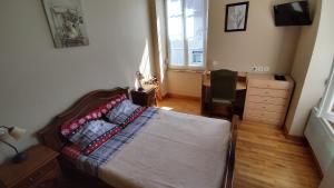 a bedroom with a bed and a dresser and a window at Le Balcon de la Pierre Claire in Villersexel