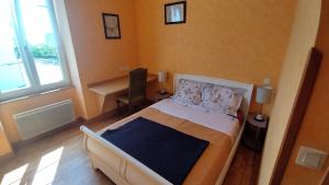 a bedroom with a bed and a desk in it at Le Balcon de la Pierre Claire in Villersexel