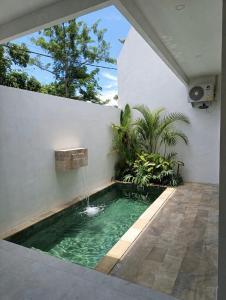 a swimming pool with a water fountain in a house at Villa Rosa Dreams 2 in Ungasan