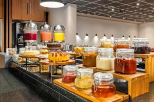 a buffet line with many jars of honey at Slim Hotel Campinas in Campinas +20 photos