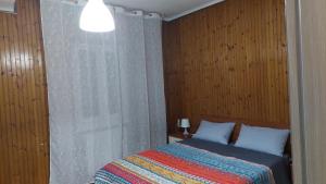 a bedroom with a bed with a colorful blanket at Ferrera case vacanze Bilocale Ilenia 15 minuti da Milano San Siro e Rho Fiera in Bareggio