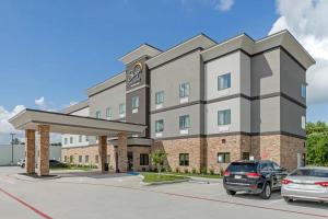 a building with a car parked in a parking lot at Sleep Inn & Suites Liberty in Liberty