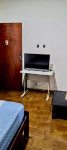 a desk in a room with a bed and a table at pousada popular in Barreiras