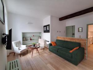 a living room with a green couch and a table at Vicolo al Duomo in Trento